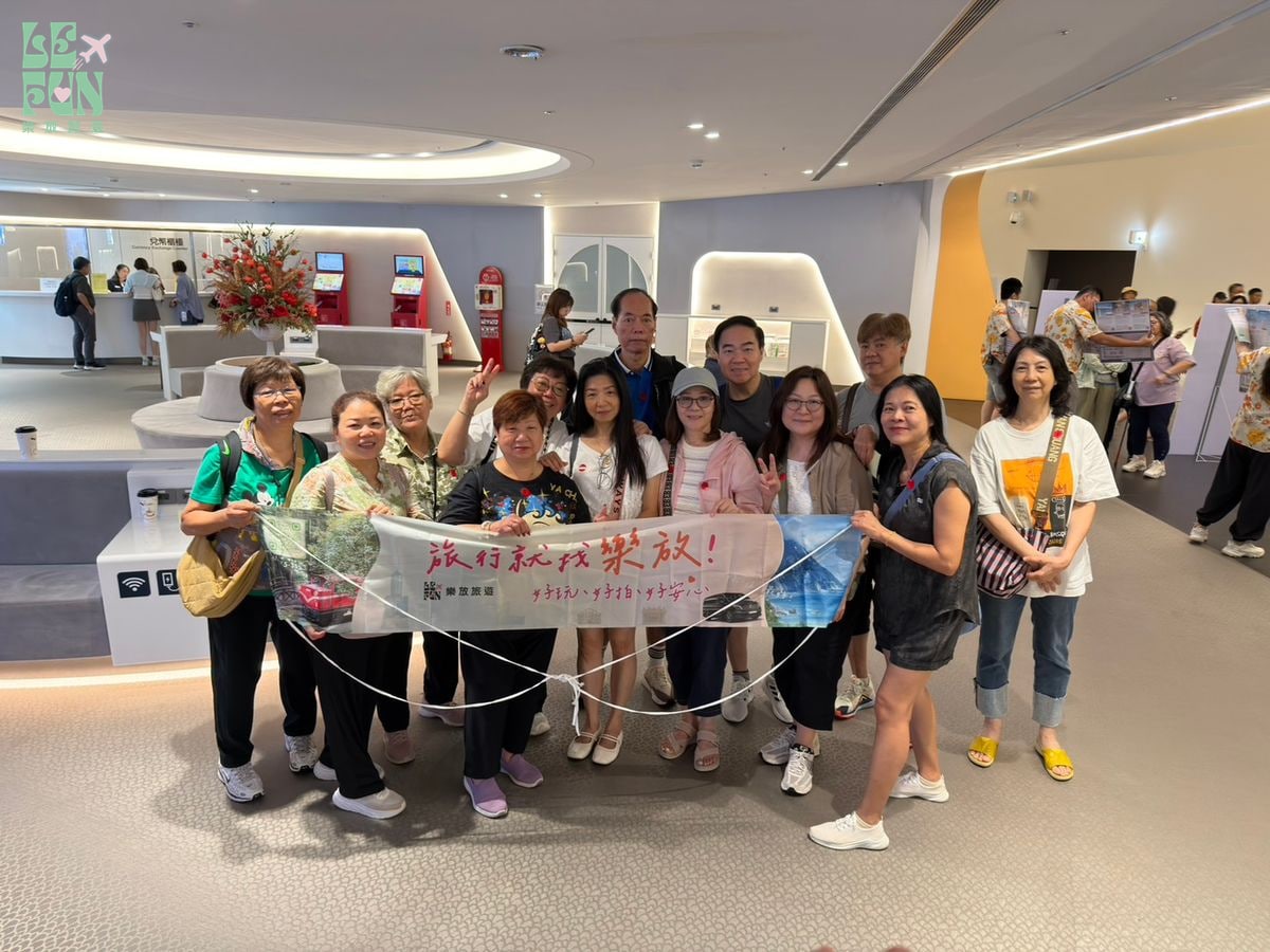團體旅客在室內展示空間合影的出遊畫面