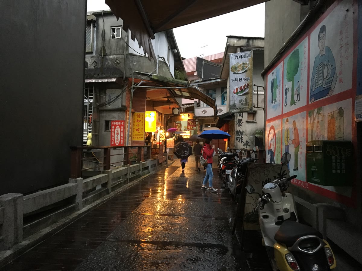 新北平溪老街雨後路面反光、彩繪牆與散步街巷